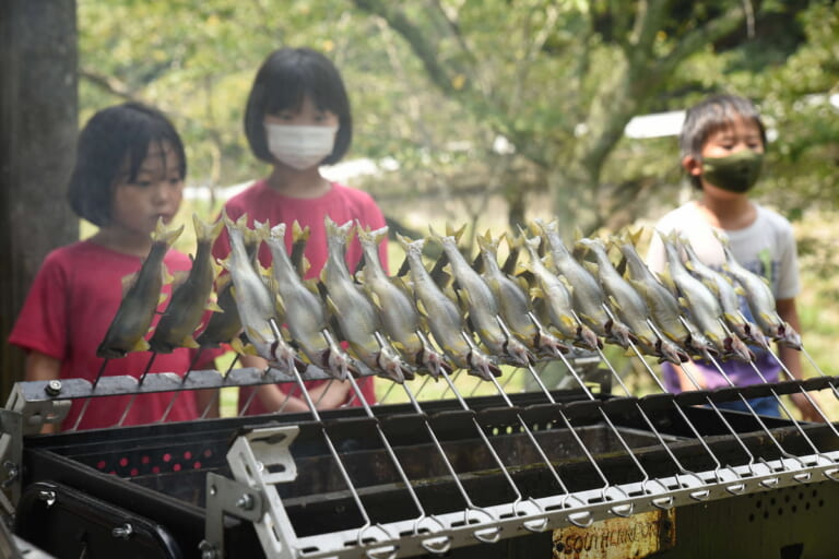 ふれあい体験でアユと戯れ自然を感じる。知明湖キャンプ場で親子連れ110人が参加  。